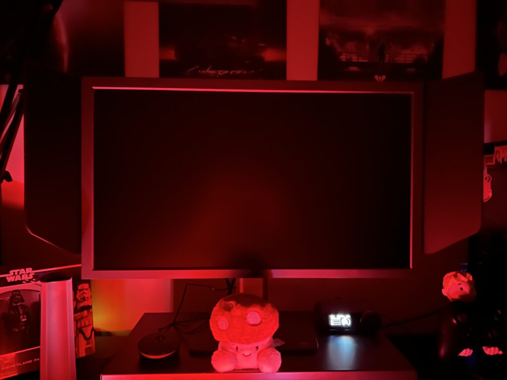 Our testing settup, red light flooding the room and the BenQ Zowie XL2566X+