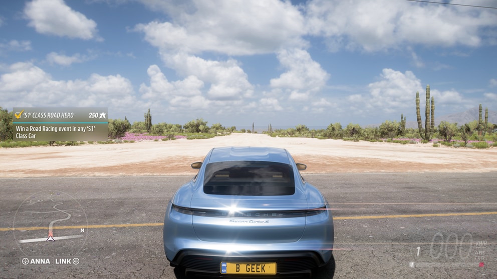 The dessert with a cloudy blue sky and sun glinting off the porsche