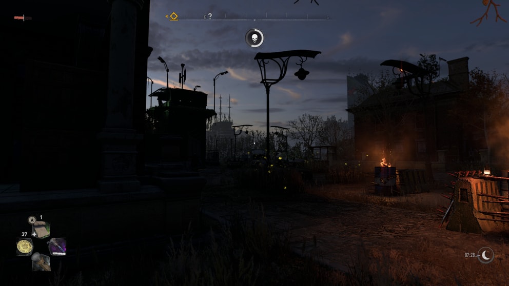 The dark city, sun setting in the distance and firebarrels giving off some light.
