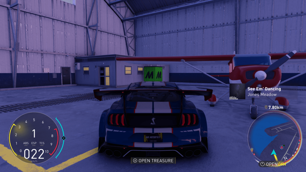 The open world is filled with treasure and items for you to find. like this green treasure chest hidden in a hangar.